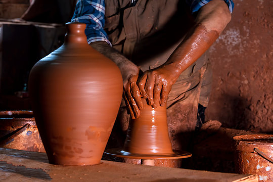 Professional potter making bowl in pottery workshop, studio.