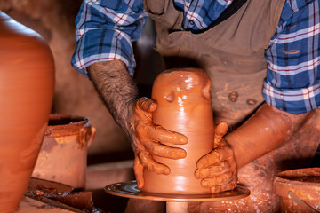 Professional potter making bowl in pottery workshop, studio.