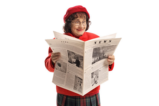 Excited senior woman with a red beret reading a newspaper