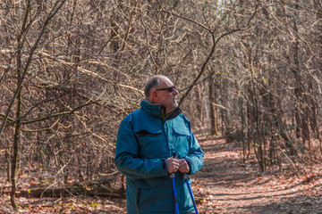 Senior sporty man nordic walking in autumn forest. - Image