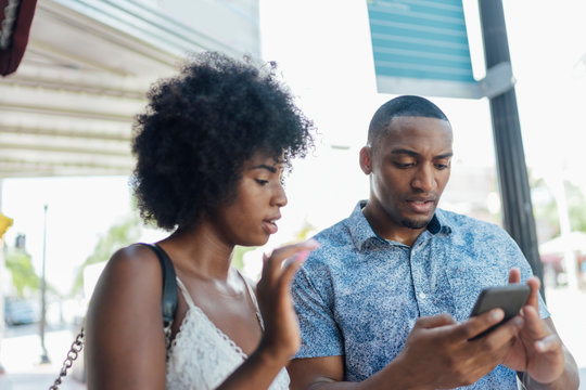 USA, Florida, Miami Beach, young couple using cell phone in the city