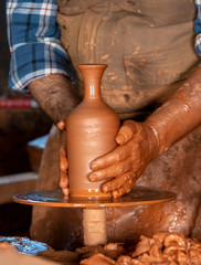 Professional potter making bowl in pottery workshop, studio.