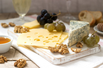 Appetizers of various types of cheese, grapes, nuts and honey, served with white and red wine. Rustic style.