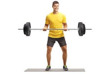 Fototapeta premium Young man in a yellow t-shirt exercising weightlifting
