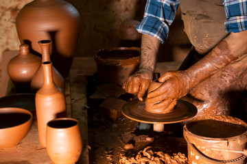 Professional potter making bowl in pottery workshop, studio.