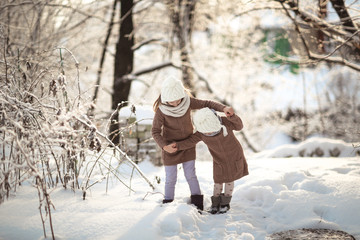 Children friends play among snowdrifts together.