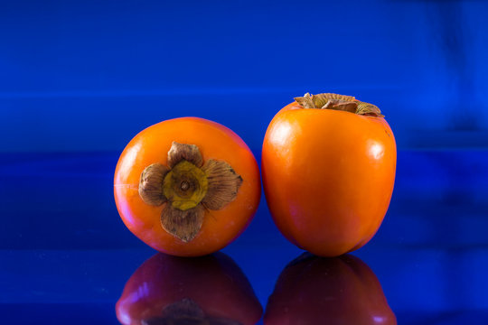 two kakis on a metallic blue background