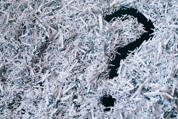 Heap of shredded paper with a symbol of question mark. concept of Questions and secret