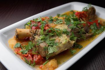 Azerbaijani buglama, on a white plate with herbs and gravy