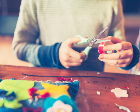 tailor art workshops for children - a girl sewing felt decorations