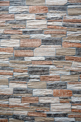 Wall finishing from colorful artificial stone trim as background front view closeup vertical