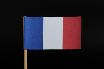 A official and simple flag of France on toothpick on black background. Consists of A vertical tricolour of blue, white, and red