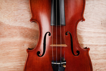 The classic violin put on wooden board,show front sideof acoustic instrument
