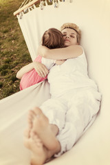 mother and a little daughter relaxing in a hammock