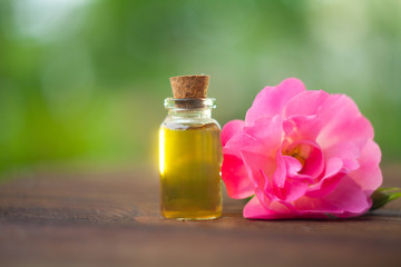 Essence of rose on table in beautiful glass bottle