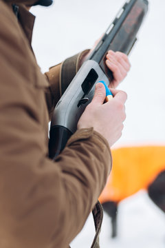 man is preparing a gun for killing birds. close up cropped photo. man is ready for shooting