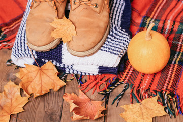 autumn composition with pumpkin, leaves, blanket, boots