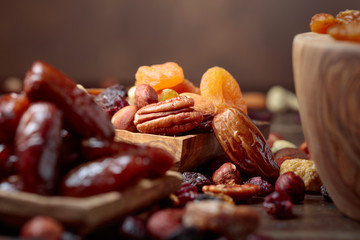 Various dried fruits and nuts in wooden dish.