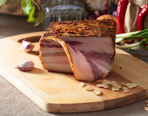 Piece of lard with garlic and spices on a kitchen table.