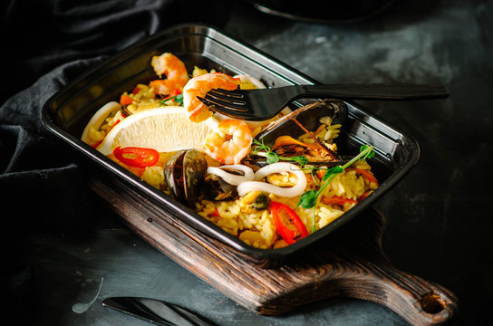 Seafood Paella In Black Box. Healthy Food And Diet Concept, Restaurant Dish Delivery. Take Away Of Fitness Meal. Weight Loss Nutrition In Boxes.