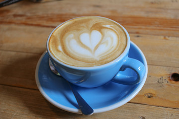 Hot coffee cup on wooden table background.