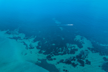 Aerial view of the tropical sea with speeding boat passing by