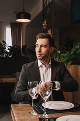 handsome man waiting for girlfriend in restaurant