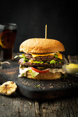 Delicious double cheeseburger with arugula and sauce - obrazy, fototapety, plakaty