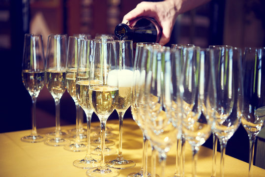 MAN WAITER PORTS CHAMPAGNE IN GLASS SHOPS ON CELEBRATIONS