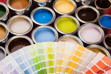 Collection of colored paints cans, red background