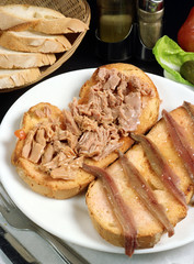 Plato con dos rebanadas de pan, una con atún y otra con anchoas