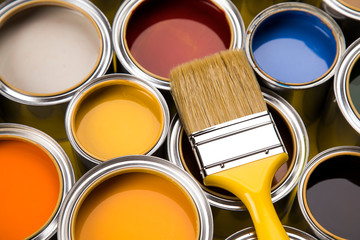 Paint can with a paintbrush, yellow background