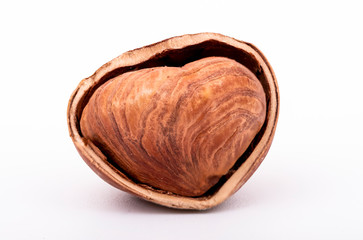 Macro photo of half hazelnut in nutshell isolated on white