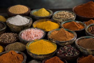 Assortment of spices in wooden bowl background