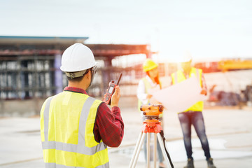 Engineer surveyor working with theodolite at construction site