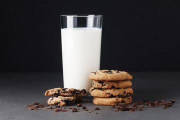 Stack of chocolate chip cookies and milk on black background. Mockup for input the text.