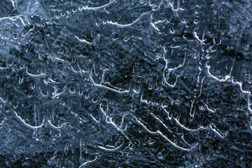 Close up of a thin ice sheet with lines and bubbles in the texture