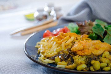 Cooked pasta with peeled shrimp, coconut milk sauce and broccoli