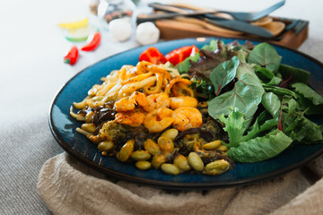 Cooked pasta with peeled shrimp, coconut milk sauce and broccoli