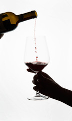 red wine is poured into a glass