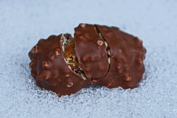 broken brown chocolate bar on white snow