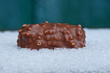 long brown chocolate bar on white snow