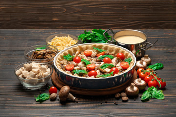 Traditional quiche tart in baking form with filling and ingredients