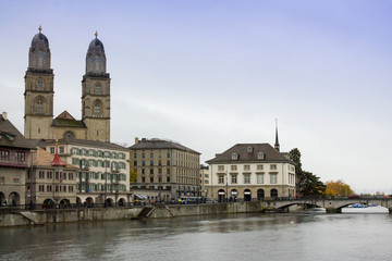 ZURICH, SWITZERLAND - OCT 130th, 2018: View of Grossmunster and Zurich old town from Limmat river. The Grossmunster is a Romanesque Protestant church in Zurich, Switzerland. Rainy weather in autumn. - 241739066