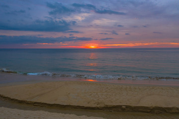 reflection of red sunset above the sea at Karon beach