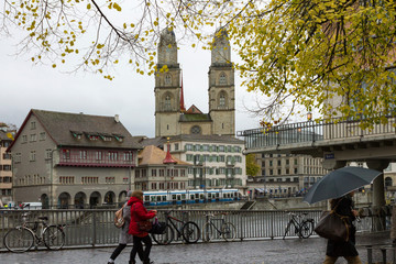 ZURICH, SWITZERLAND - OCT 130th, 2018: View of Grossmunster and Zurich old town from Limmat river. The Grossmunster is a Romanesque Protestant church in Zurich, Switzerland. Rainy weather in autumn. - 241739292