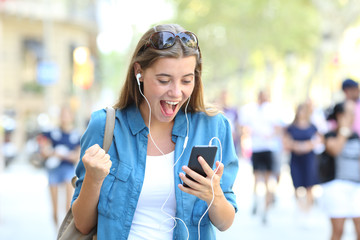 Excited girl listening to online music outdoors