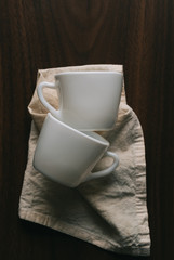 White ceramic cups on napkin