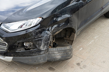 Damage to the front wheel and bumper in an accident.