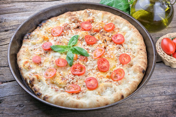 Closeup of homemade pizza on wooden background